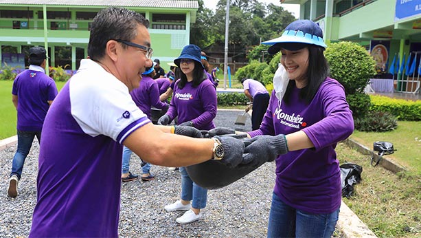 Mondelez employees in purple Mondelez shirts working outside.