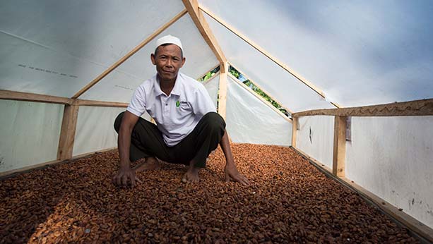 Woman smiling while eating toast with Philadelphia cream cheese spread on it.