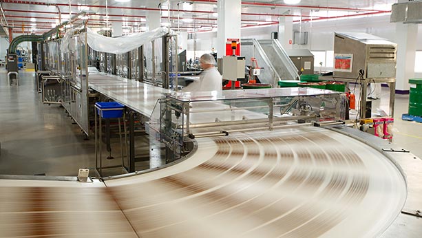 Assembly line moving fast with 1 worker in background.